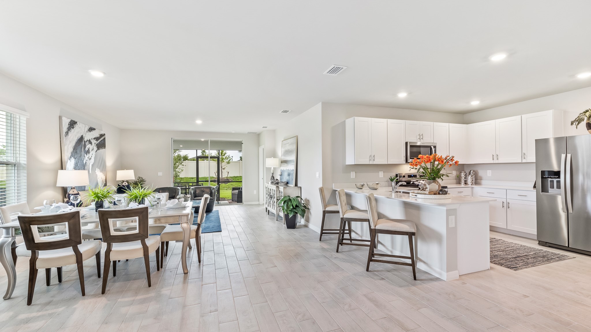 Inside of the Carrington model kitchen and dining room. All staineless steel appliances and white cabinetry.