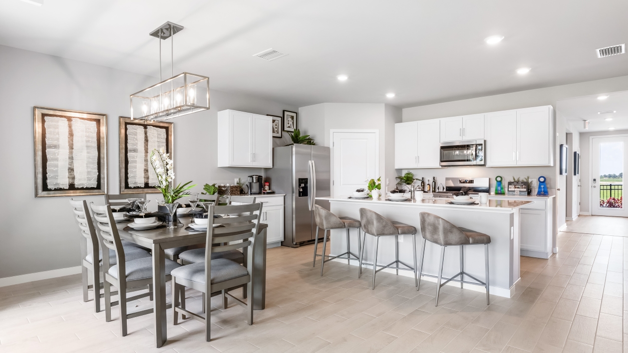 Inside of the Cali model kitchen. This angle shows the dining area with a six-person dining table and chairs.