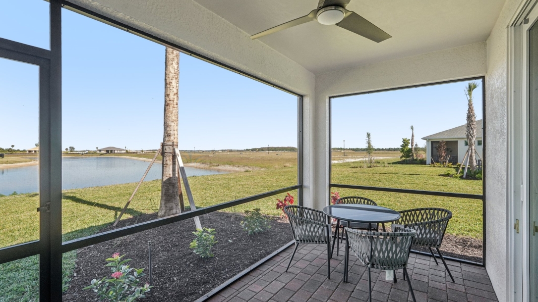 The patio of the Carrington model. Screened in lanai with a table and seating for 4.