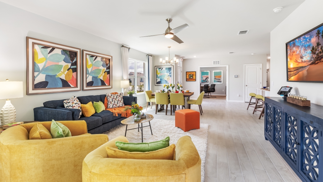 Colorful living room and dining area with a view into the den and kitchen.