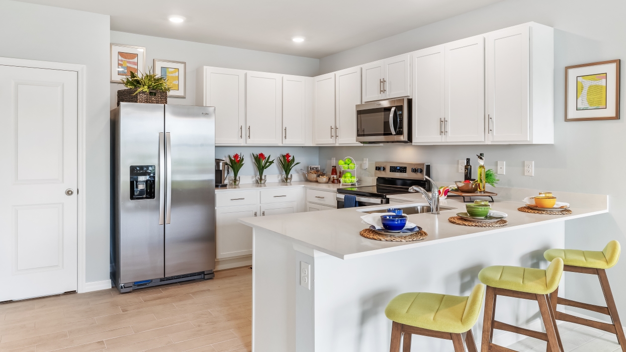 Kitchen with white cabinets, stainless steel appliances, and a peninsulta for bar-style eating.