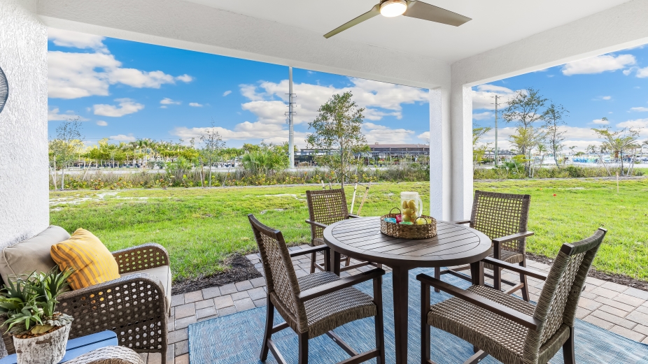 Covered lanai with outdoor table and chairs.