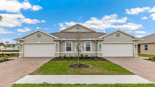 Outside of the Carrington Model. Twin Villa home, with side entrance and mixed paver driveway.
