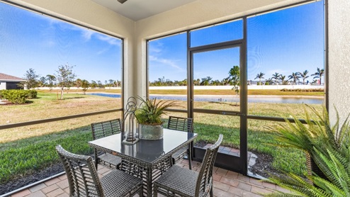 Outside the Cali Model screened-in Lanai with a table and chairs and plants