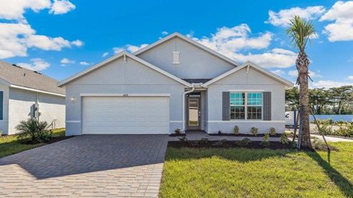 Exterior elevation of light gray home with white trim, gray door and gray shutters.