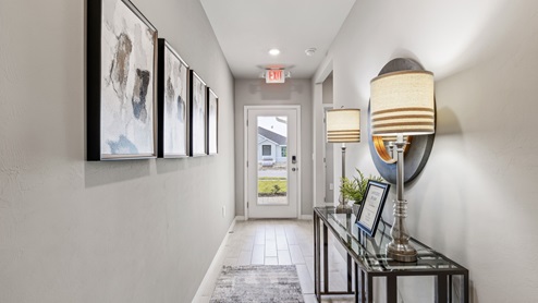 Inside of the Lakeside model hallway. Tile flooring, Grey walls. Hallway to the front door and den area.