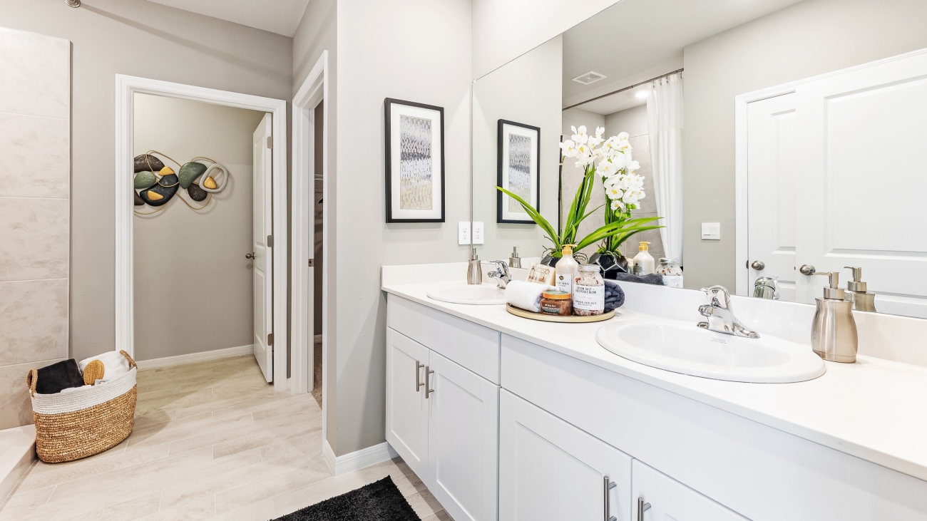 This is the Lakeside's master bathroom, The shower is tiled without a tub and and the dual sinks have silver fixtures. You can also access the master closet through here.