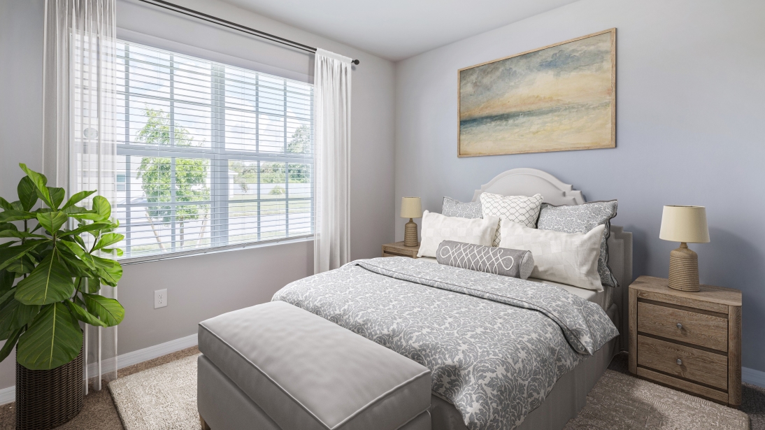 Inside the Primary bedroom of the Lakeside. Carpetted floors and gray walls with Farmhouse style décor. There is a window for viewing the landscaped area outside.