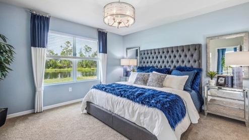 Inside of the Jemison model bedroom one. Grey carpet with off-white walls. Room contains one bed with nightstands on either side, a dresser on the opposing wall, and a plant in the corner of the room. Room also contains a window.