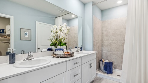Inside of the Jemison Model bathroom with white cabinetry and white toilet and shower.
