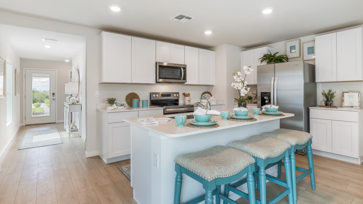 Inside of the kitchen. Stainless steel appliances, quartz countertops, walk-in corner pantry.