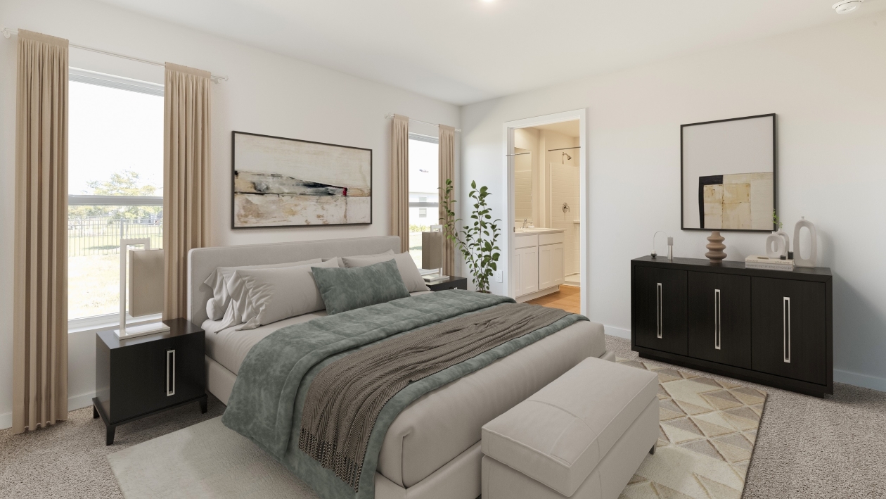 Inside the Downing model bedroom 3. Large bed with side tables on either side of the bed, a dresser next to the bed, and a benche at the end of the bed. Room also has two windows and a connected bathroom.