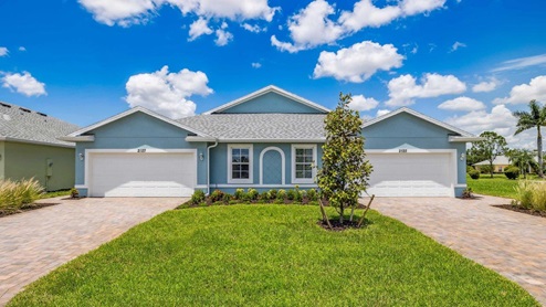 Outside of the Carrington model. Blue home with two windows, two garages, two front doors. Two grey paver driveways.