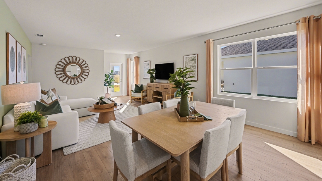 Inside of the Harper model in Central, FL. View of the dining room with the living room behind it.