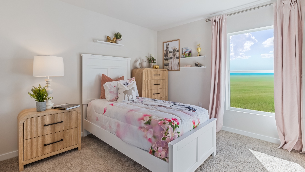 Inside the Freeport model bedroom 2. Twin bed with side table and dreeser on either side. Room also contains a window.