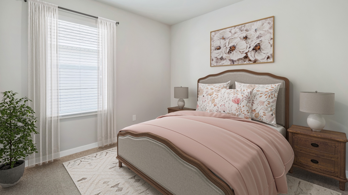Inside the Secondary bedroom of the Lakeside. Carpetted floors and gray walls with Farmhouse style décor. There is a window for viewing the landscaped area outside.