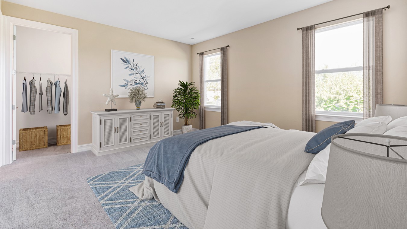 Inside the Kellen model Master Bedroom with view of the two windows and the master closet. Walls are tan and carpet is gray.  Bedding is gray/blue. Dresser is against the wall next to a plant.