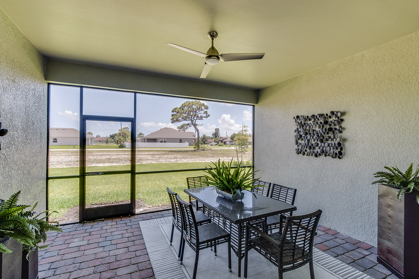 Covered lanai with screen and outdoor furniture.