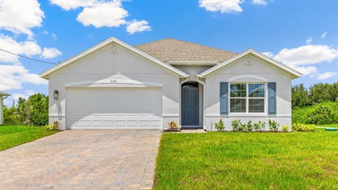 Outside of the Cali C model. Beige home with a two car garage, one window with shutters, and front door. Mixed pavers driveway.