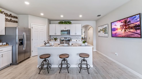 Inside of the Cali model kitchen. This angle shows the hallway leading to the other rooms and front door.