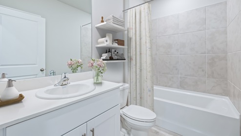 Lakeside Secondary bathroom with tiled shower and white tub.