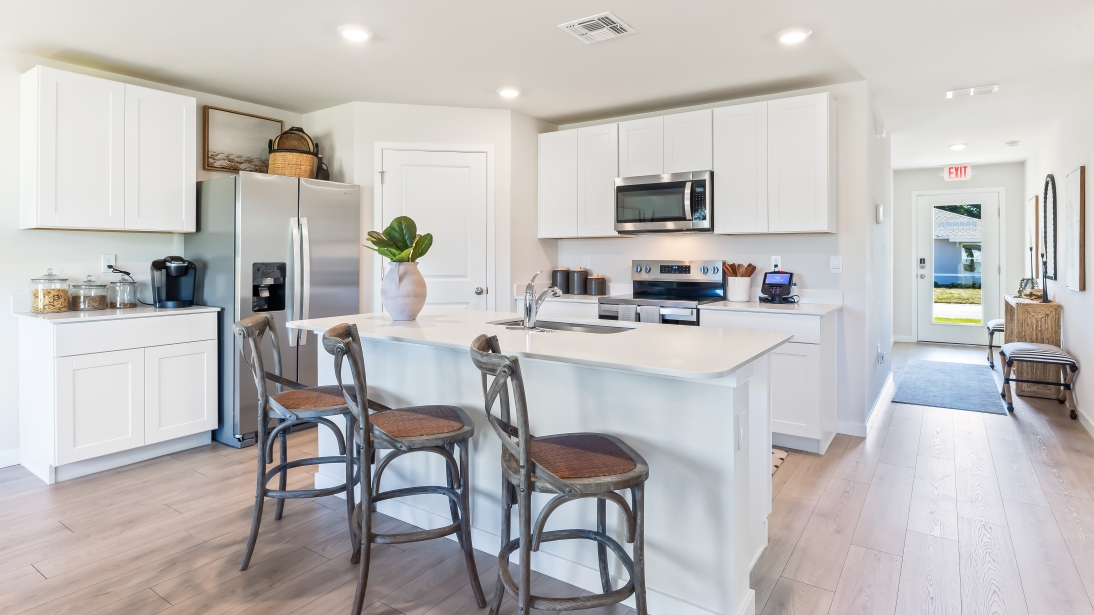 Inside of the kitchen. Stainless steel appliances, quartz countertops, walk-in corner pantry.