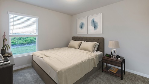 Inside the Freeport bedroom three. Off-white walls with creme carpet. Room contains a large bed with medium nightstand next to it. Also contains a dresser across from bed. Window connected to room.