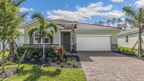 Outside of the Clifton model A. Brown home with two car garage, one window with shutters, and front door. Mixed paver driveway.