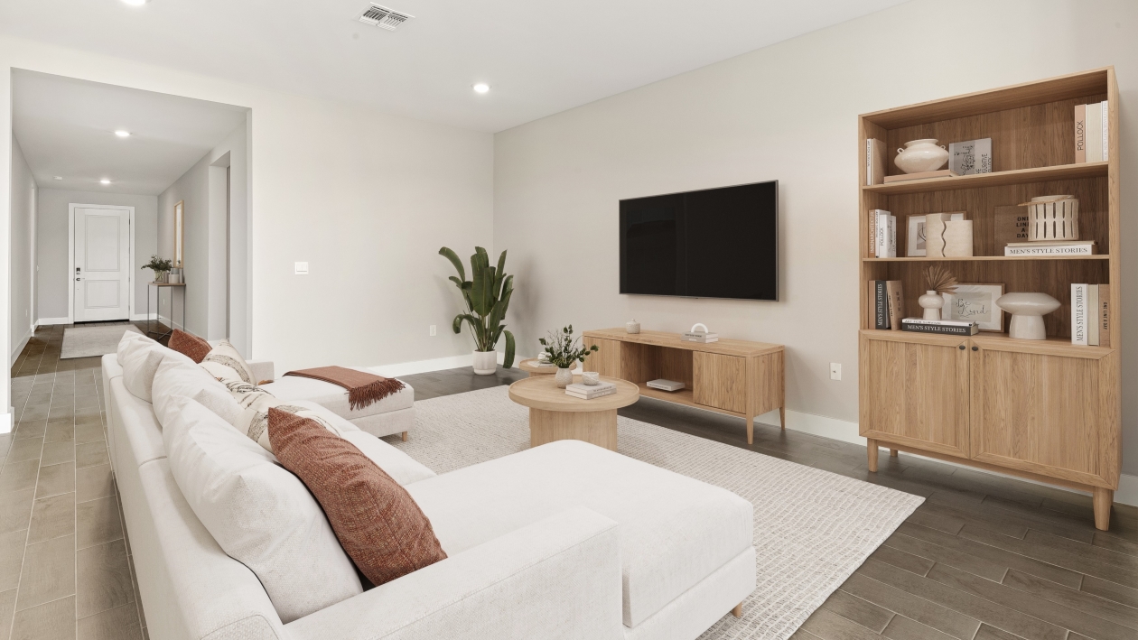 Inside of the Shelby model home living room with tv, bookshelf, couch and coffee table.