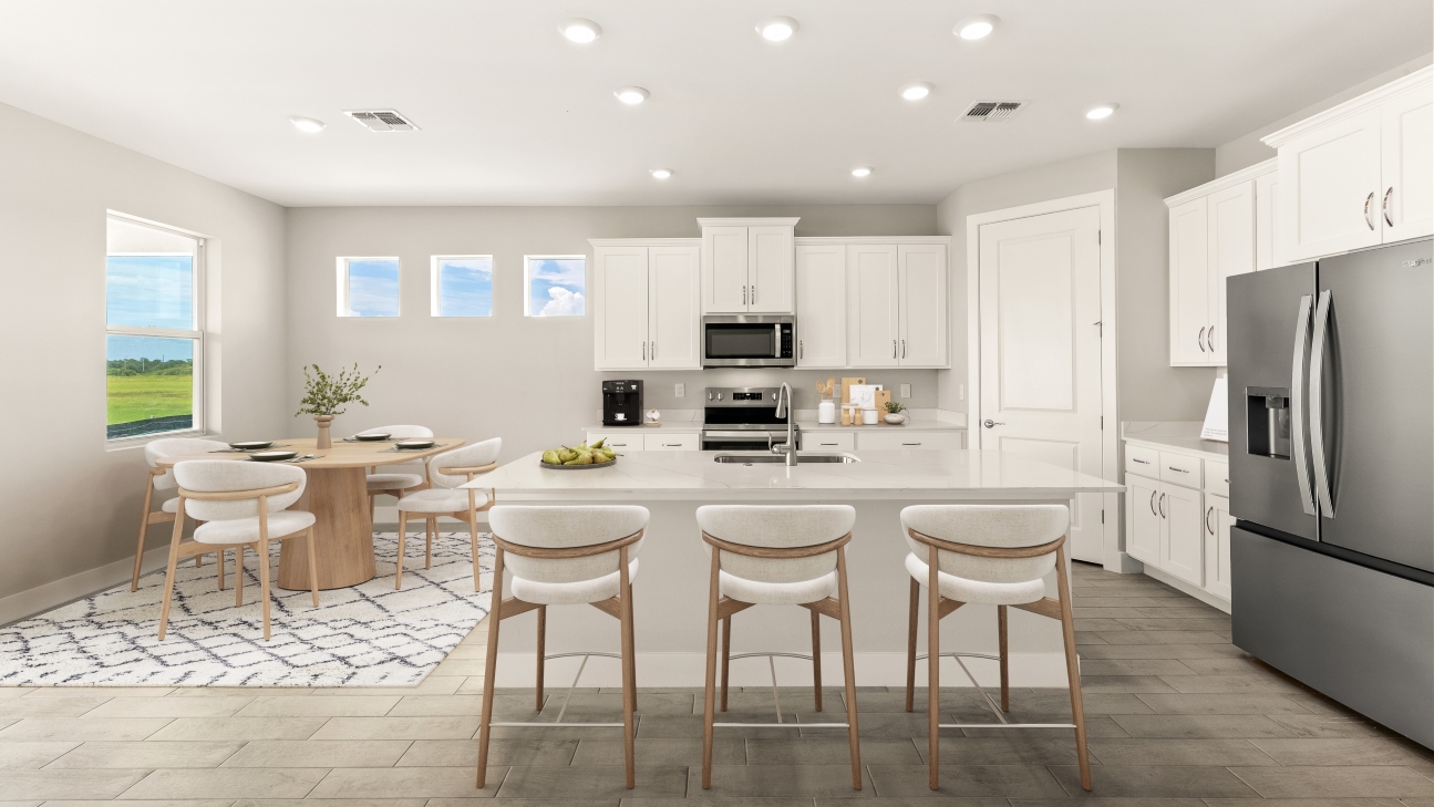 Inside of the Shelby model home kitchen with bar setup and dining room to the left of the cabinets.