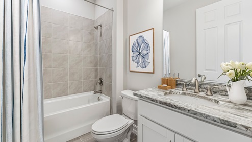 Inside the Clifton secondary bathroom, tub included in shower and single sink. toilet is inbetween the two.