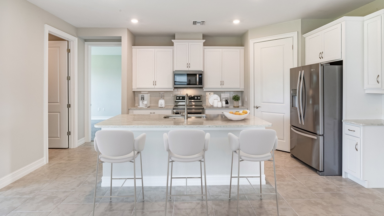 Inside of the Clifton A.  Kitchen has stainless steel appliances. There is bar seating in the kitchen.