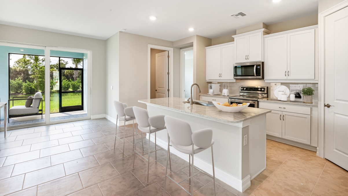 Another angle of the Inside of the Clifton.  Kitchen has stainless steel appliances. There is bar seating in the kitchen. This angle you can see the lanai