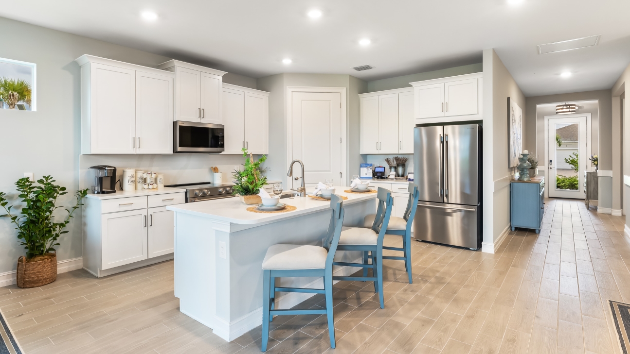 Inside of the of the Delray Model kitchen area. Kitchen has stainless steel appliances. There is bar seating in the kitchen.