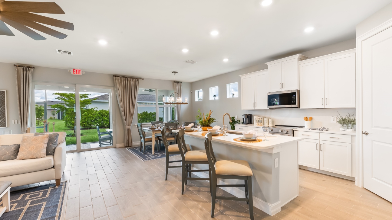 Inside of the of the Delray Model kitchen area. Kitchen has stainless steel appliances. There is bar seating in the kitchen.