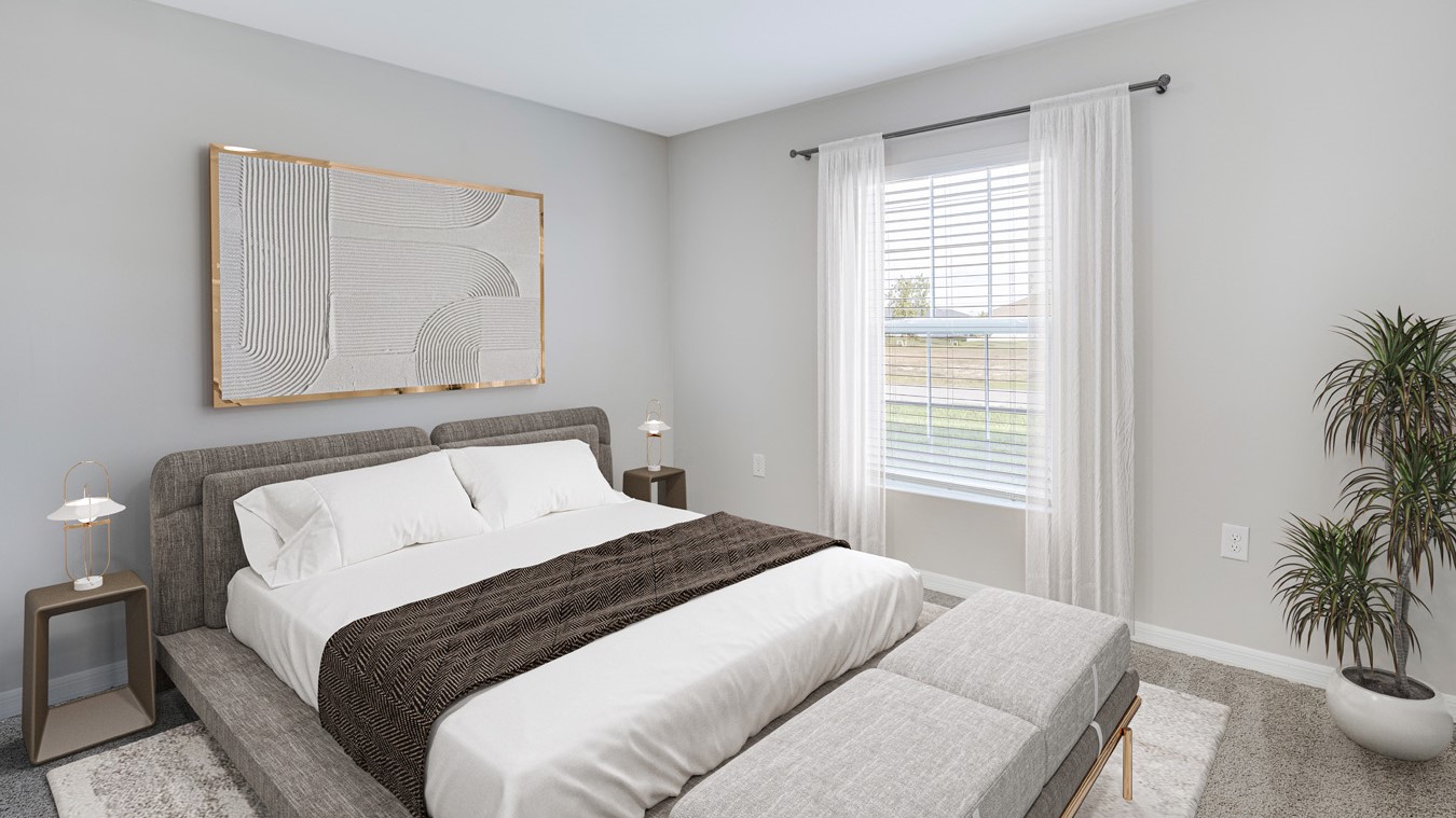 Inside of the Boardwalk model bedroom two. Off-white walls with beige carpet. Room contains one bed with white sheets, small nightstands on either side of the bed, and small plant in the corner of the room. Room also contains a window.
