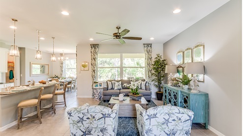 Open concept living space including the living room, kitchen island and dining area.