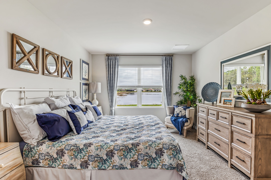 Inside of the Cali model bedroom one. This photo shows a large dresser in the room across from the bed.