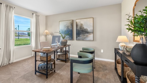 Inside the third bedroom of the Lakeside. Carpetted floors and gray walls with Farmhouse style décor. There is a window for viewing the landscaped area outside.