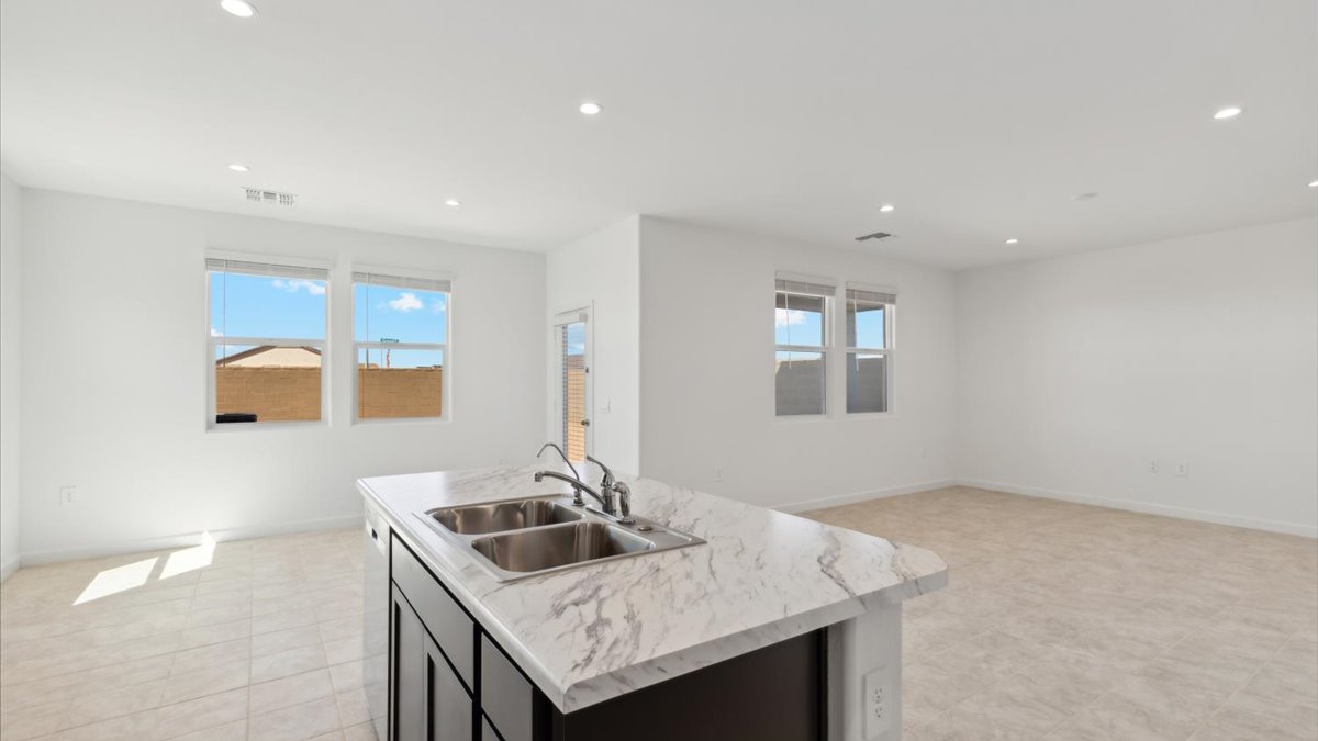 Kitchen island with dual sink overlooking the living area and dining nook