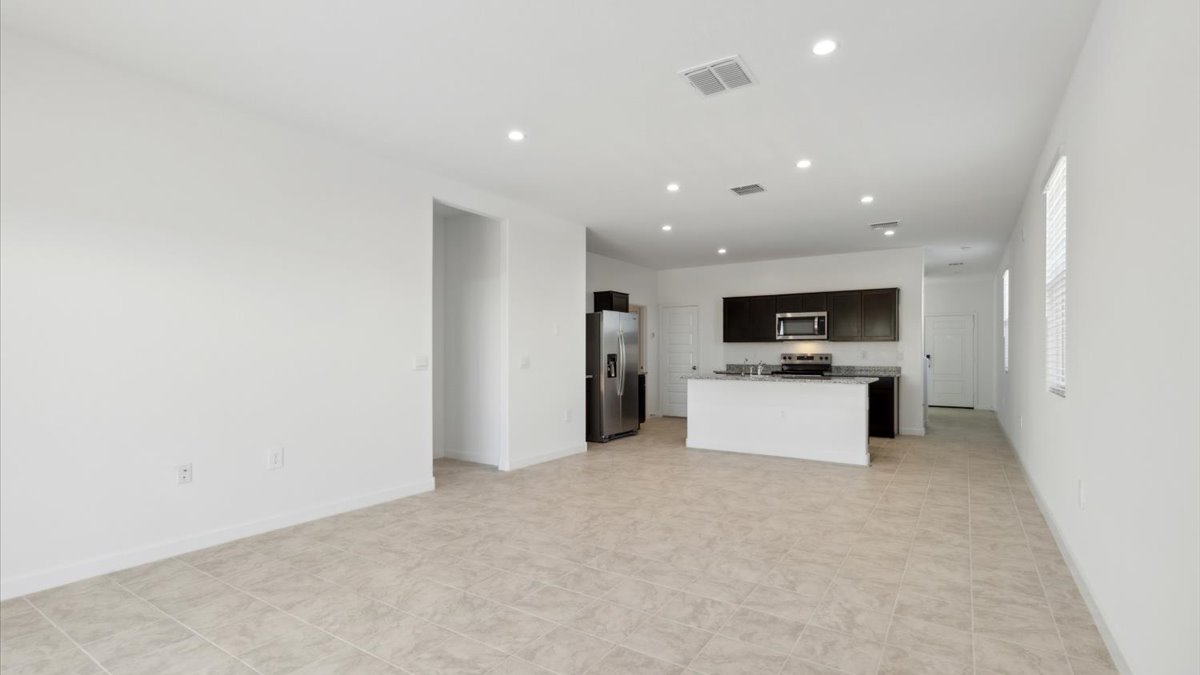 A well-organized living room that includes a kitchen and dining area, creating a warm and welcoming environment for gatherings.