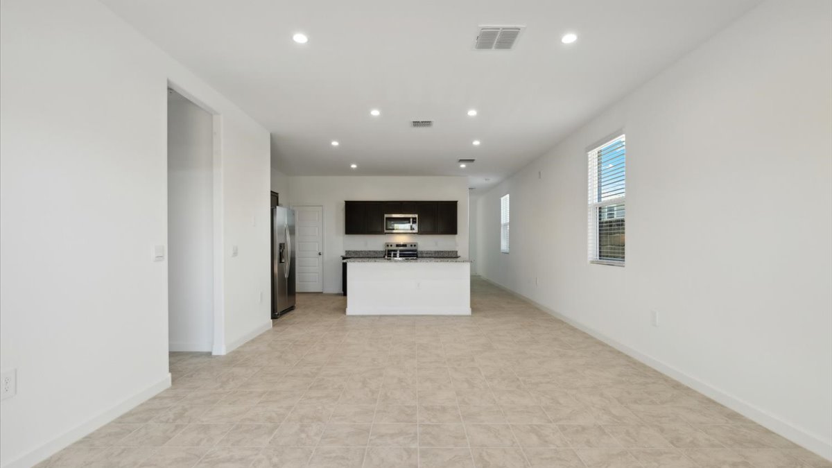 A well-organized living room that includes a kitchen and dining area, creating a warm and welcoming environment for gatherings.