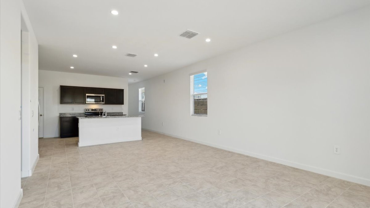 A well-organized living room that includes a kitchen and dining area, creating a warm and welcoming environment for gatherings.