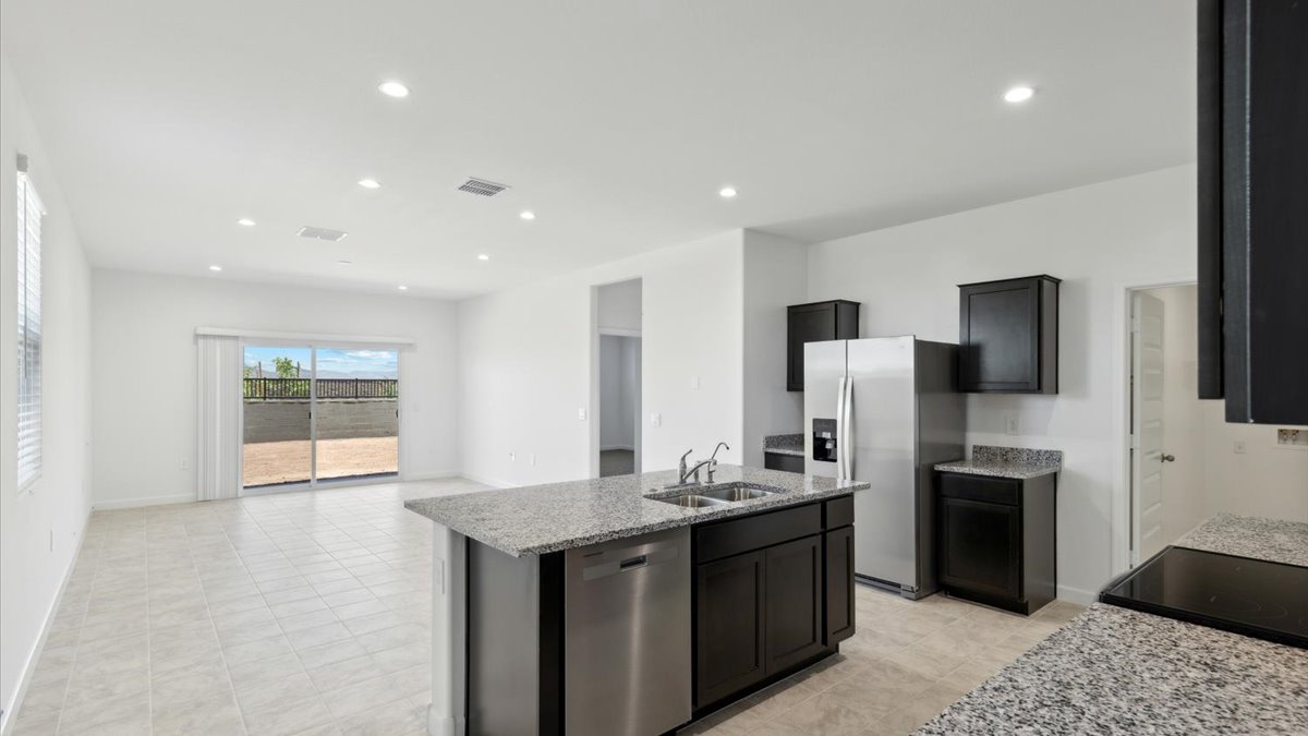 Bright and spacious kitchen with granite countertops, stainless steel appliances, and an island with bar seating.