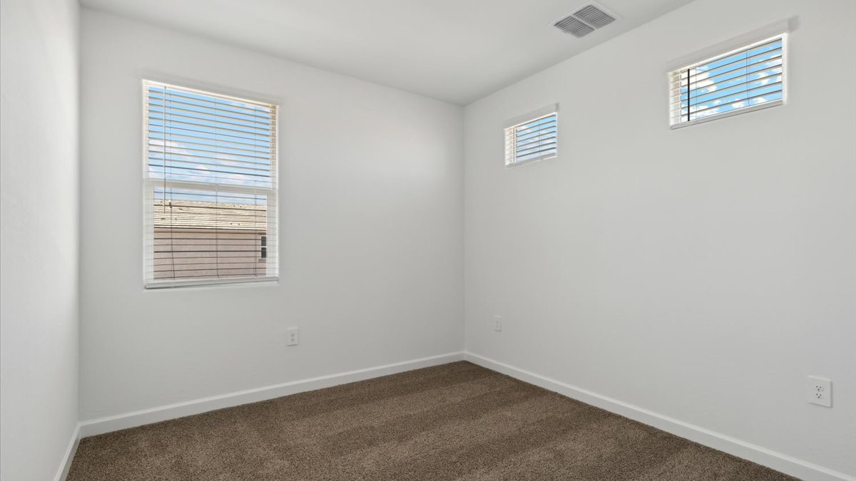 Comfortable guest bedroom featuring neutral-toned walls and a large closet.