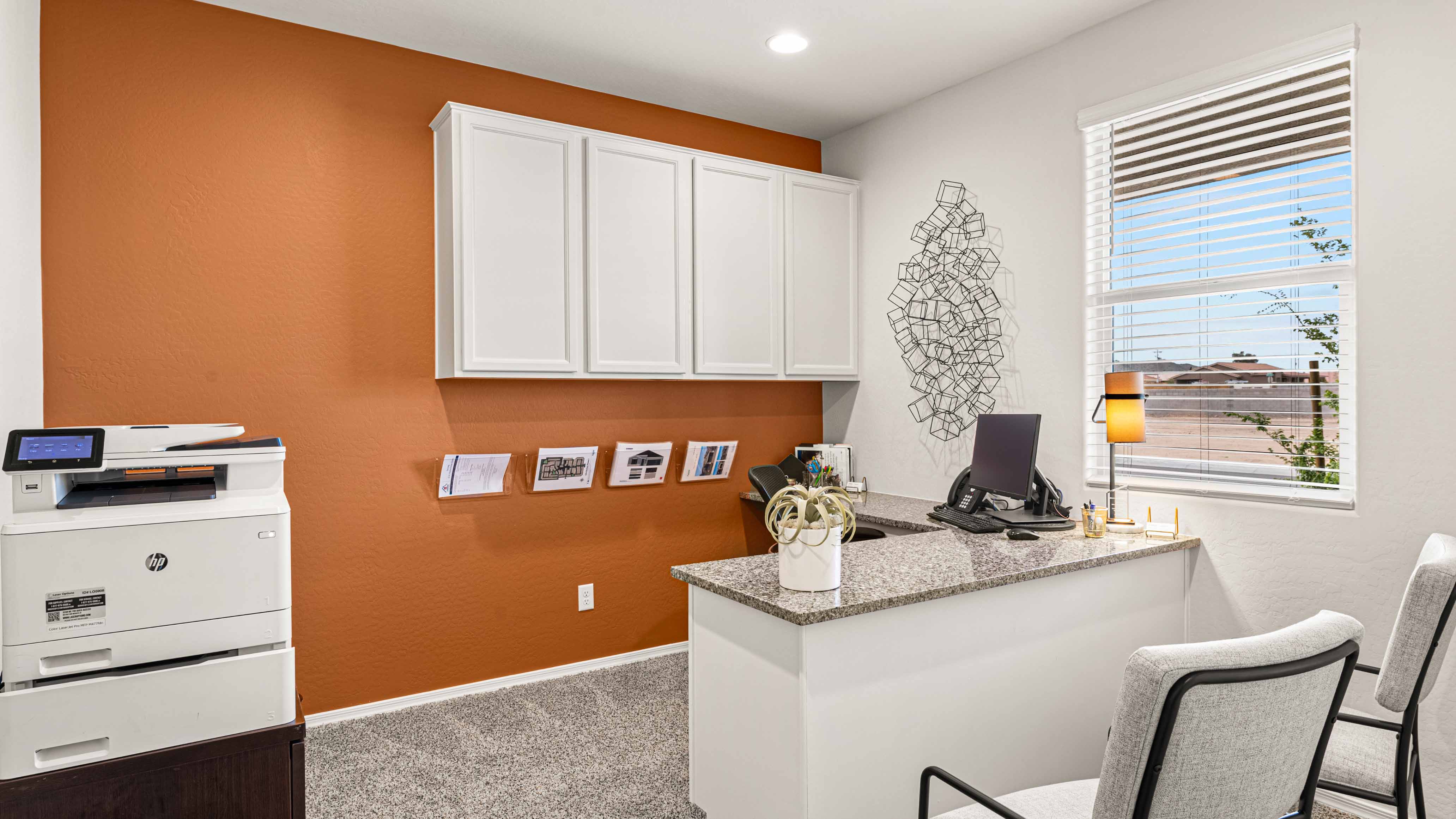 A tidy office featuring a desk, chair, and a window, creating a bright and organized workspace.