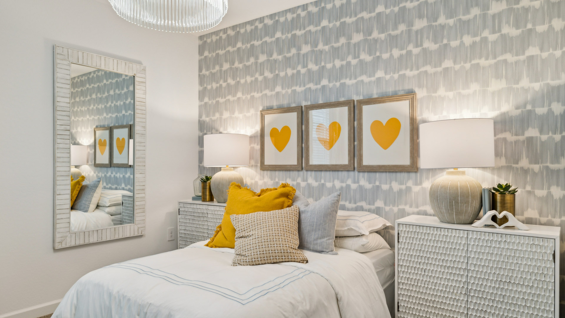 A vibrant kids' bedroom showcasing a neatly made bed, a stylish dresser, and a playful painting that adds charm.