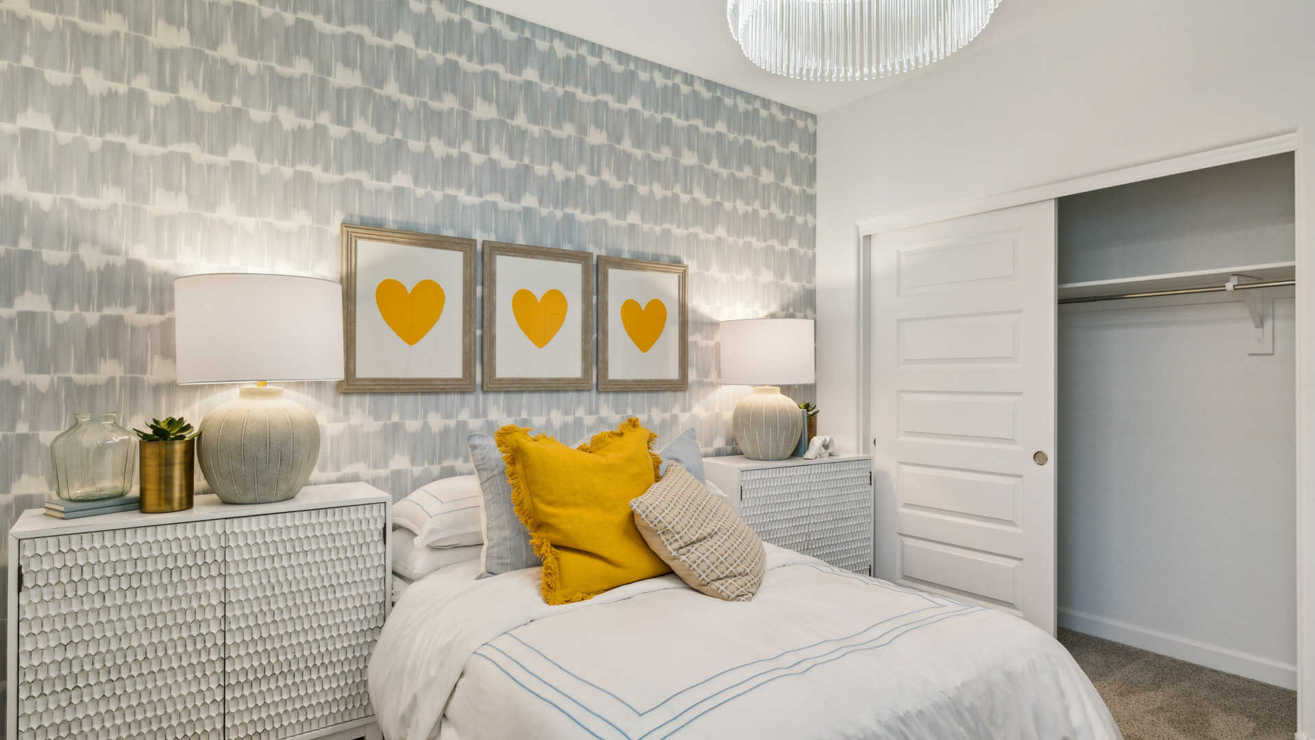A vibrant kids' bedroom showcasing a neatly made bed, a stylish dresser, and a playful painting that adds charm.