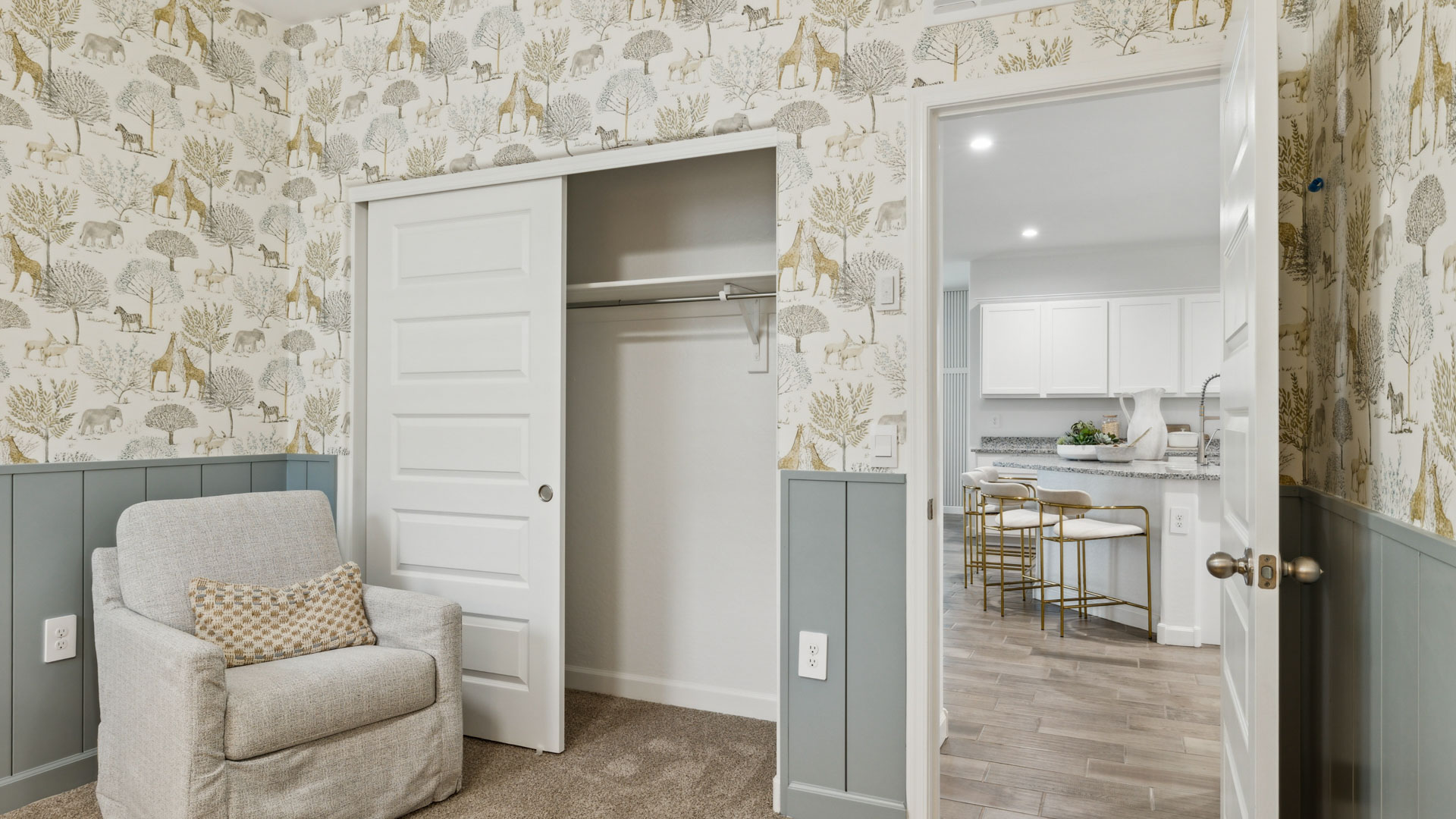 A cozy baby's room featuring a crib, a comfortable chair, and a bright window allowing natural light to enter.