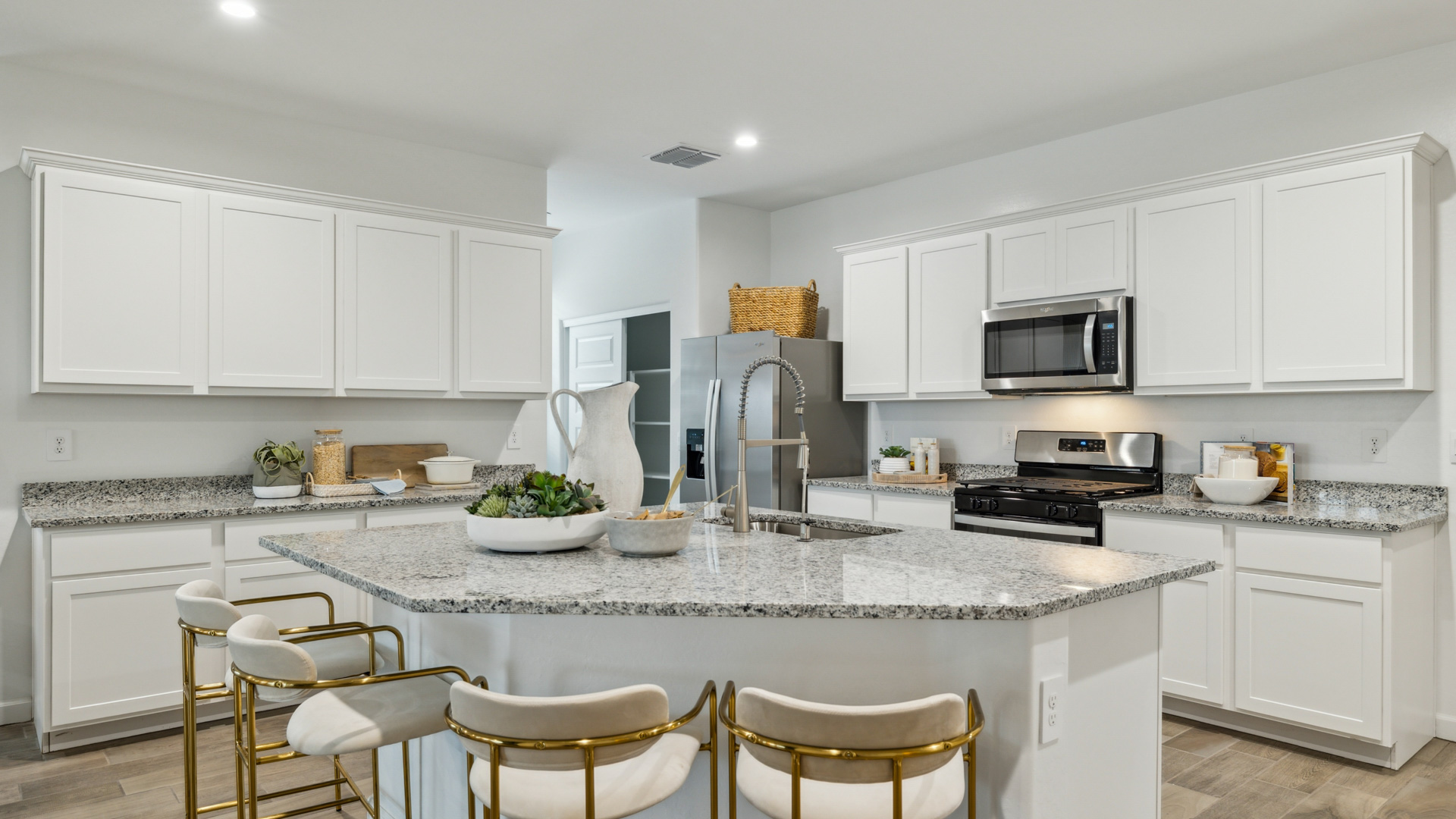 Bright and spacious kitchen with granite countertops, stainless steel appliances, and an island with bar seating.